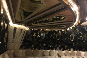 Une pièce dotée d’un plafond au design original, d’un coin salon avec un mur à motifs et d’une collection d’objets de forme circulaire.
