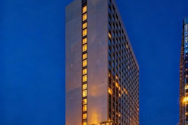 A tall building with a vertical light strip and a grid-like facade.