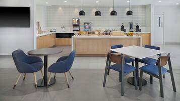 A modern kitchen with a central island, built-in appliances, and pendant lighting.