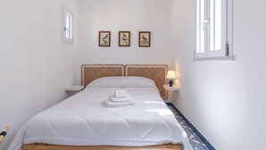A neatly made bed with white bedding and a headboard, a bedside table with a lamp, and three framed bird paintings on the wall. - Zisa Top Romantic terrace & private outdoor Jacuzzi (Palermo)