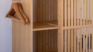 Ein Holzschrank mit drei Einlegeböden und einer Kleiderstange.