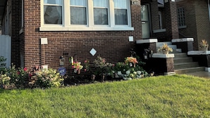 A two-story house with a brick facade, large windows, and a front porch with potted plants. -  3-bedroom apt .on North Side! Great location between downtown and the airport. (Chicago)