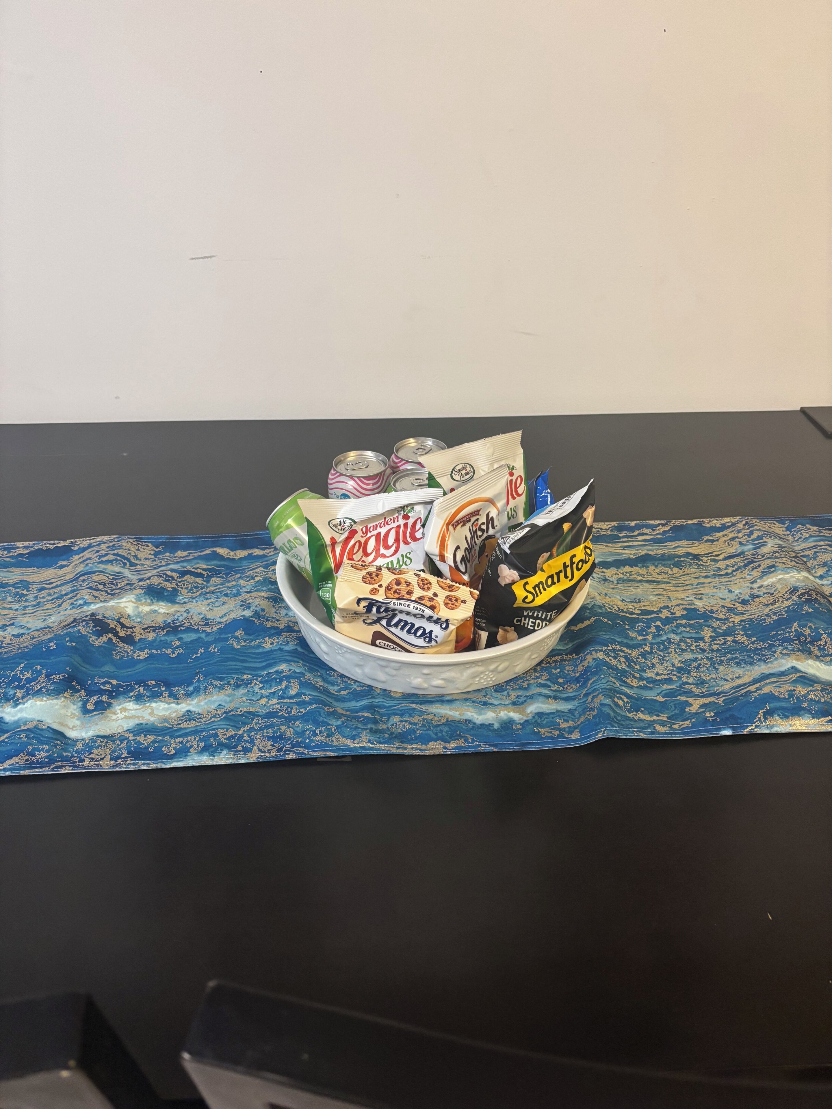 A bowl of snacks on a table with a blue patterned mat.
