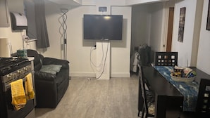 A compact living space with a kitchen, dining area, and a flat-screen TV mounted on the wall. -  3-bedroom apt .on North Side! Great location between downtown and the airport. (Chicago)