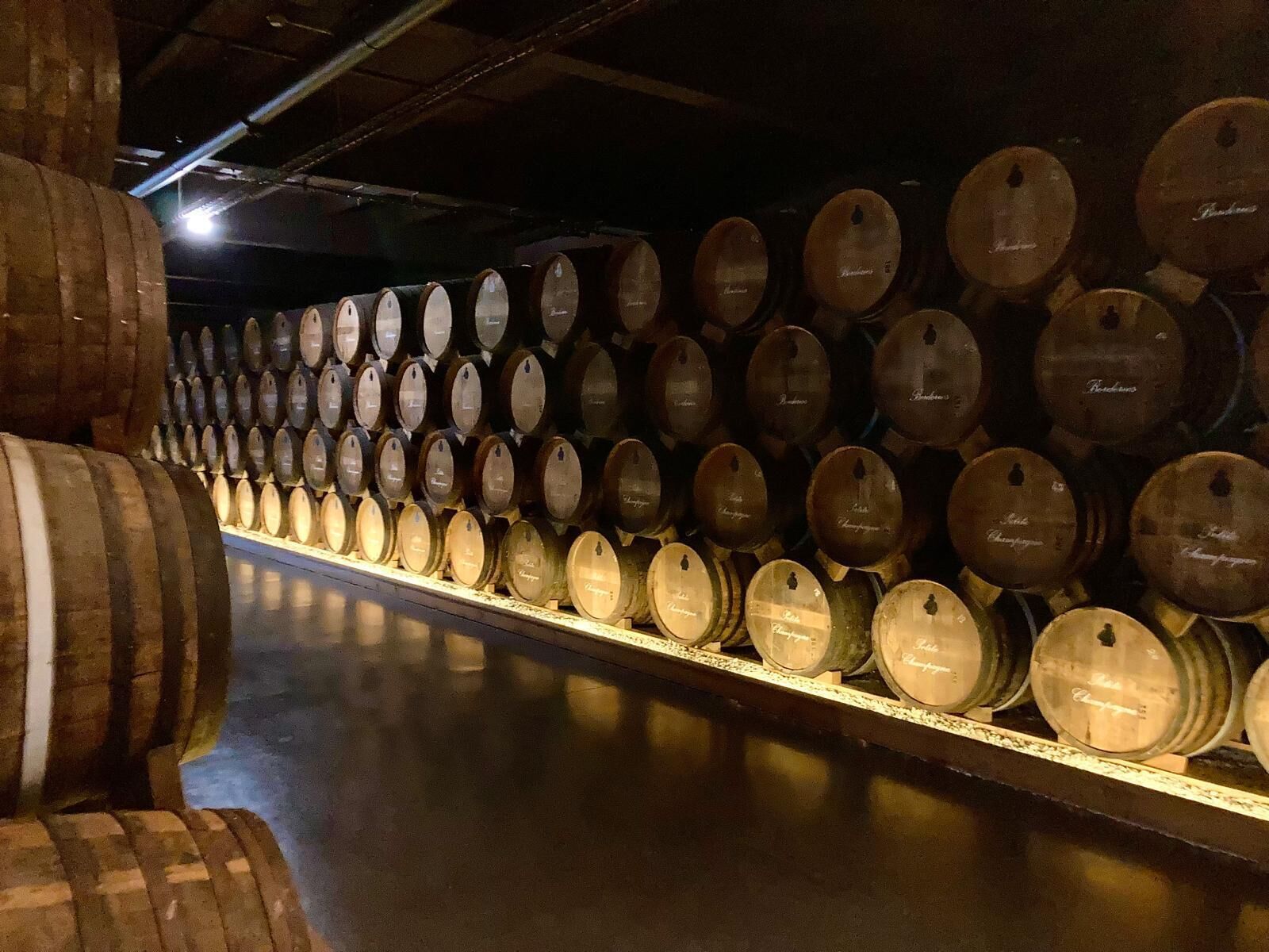 Une rangée de barils en bois dans un entrepôt.
