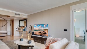 Een moderne woonkamer met een bank, een salontafel en een flatscreen televisie.