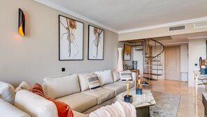 Een moderne woonkamer met een bank, een salontafel en kunst aan de muur.