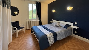 Une chambre à coucher avec un lit, une chaise, une fenêtre et des appliques murales.