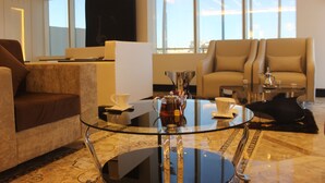 Una sala de estar moderna con una mesa de centro de vidrio, sofás de cuero y un televisor de pantalla plana.