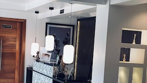 Una moderna área de recepción con mostrador de mármol, iluminación colgante y un mostrador de recepción.