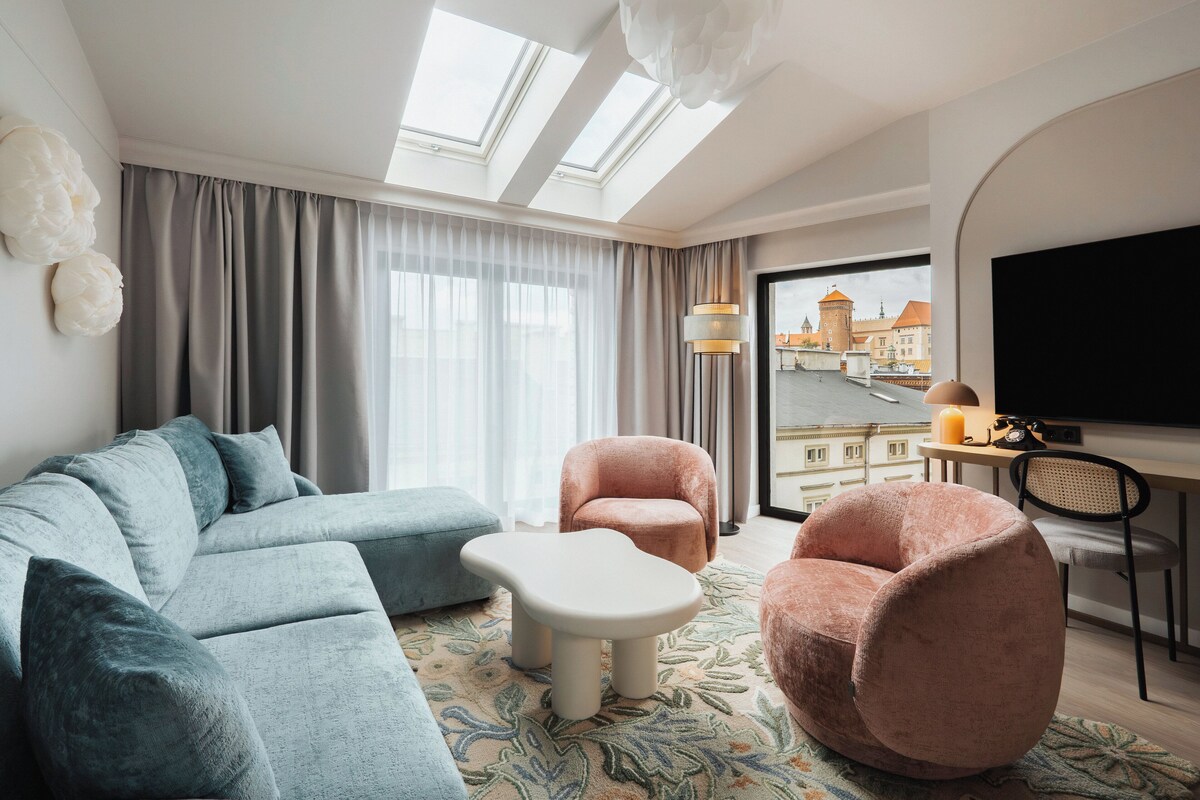 Una sala de estar moderna con un sofá, dos sillones, una mesa de centro y una televisión.