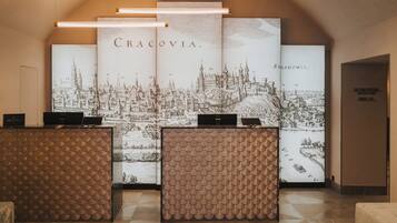 A reception area with a large cityscape illustration, a modern reception desk, and a sign for a conference room.