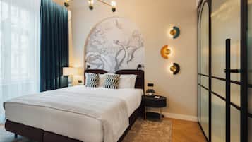 Habitación de hotel con una cama grande, una mesita de noche, una lámpara de pared y un adorno mural.