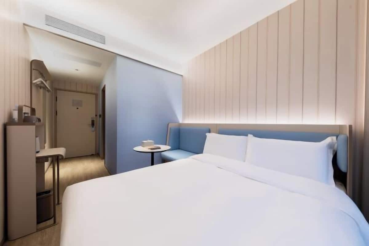 Une chambre d’hôtel avec un lit, une petite table, une chaise et un bureau.