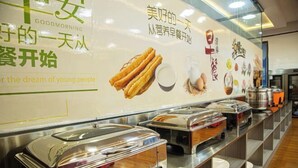 A buffet area with various food items and a wall with promotional text and images. - Quzhou Ying Hotel (Quzhou)