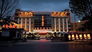 A hotel with a prominent entrance, multiple floors, and illuminated signage. - Quzhou Ying Hotel (Quzhou)