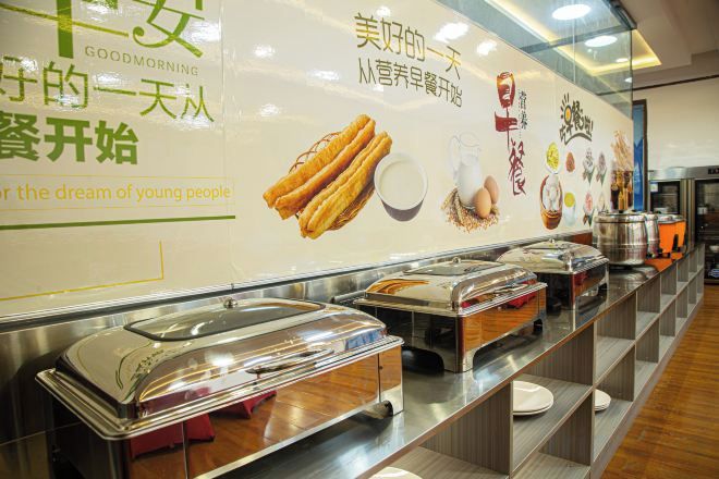 A buffet setup with multiple food service stations, a wall with promotional text, and a clean, organized layout.