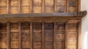 Sostres de fusta amb una estructura de bigues i una decorativa cornisa.