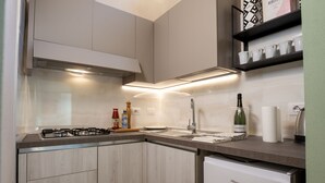 Una cuina moderna amb fogó a gas, rentamicroones d'acer inoxidable i forn integrat.