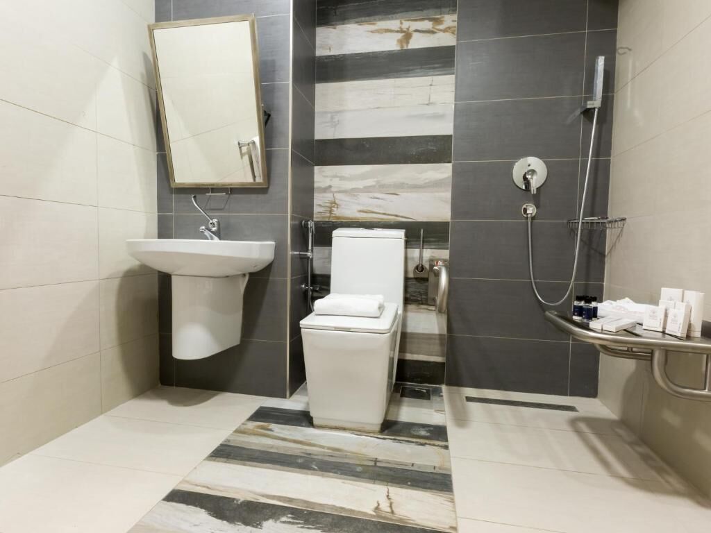 A bathroom with a sink, toilet, and shower.