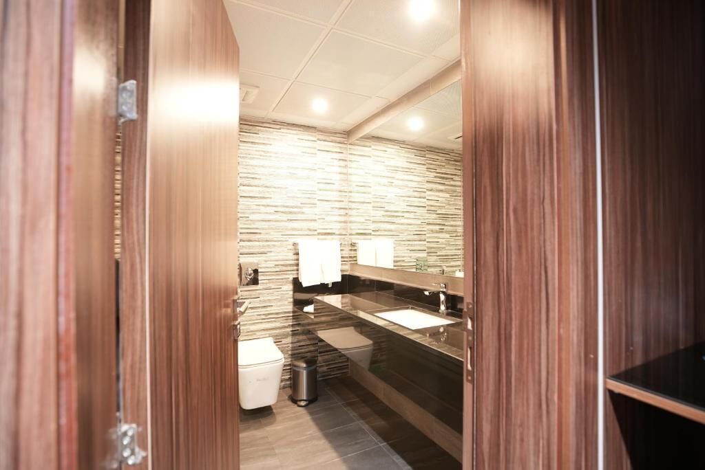 Un bagno moderno con uno specchio grande, un lavandino e un water.