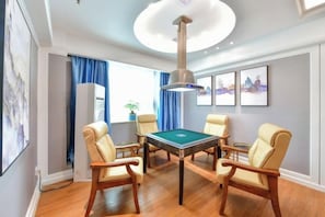 A room with a pool table, four chairs, a ceiling light fixture, and framed artwork on the wall. - Junfu Hotel (Guangzhou Panyu Square Metro Station) (Guangzhou)