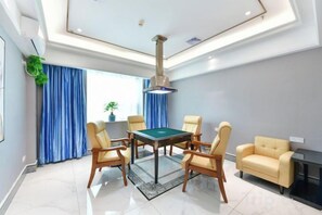 A room with a billiards table, four chairs, a sofa, a fireplace, and a large window with curtains. - Junfu Hotel (Guangzhou Panyu Square Metro Station) (Guangzhou)