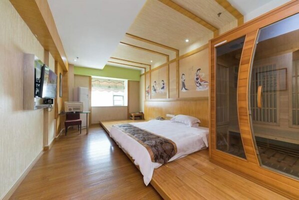 A hotel room with a large bed, a desk, a chair, and a TV. - Junfu Hotel (Guangzhou Panyu Square Metro Station) (Guangzhou)