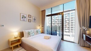 A modern hotel room with a large bed, a nightstand, a TV, and a balcony with a city view. - Azizi Riviera 8 - Quiet Studio in Meydan (Meydan)