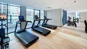 A modern gym with treadmills, an elliptical, and a stationary bike. - Azizi Riviera 8 - Quiet Studio in Meydan (Meydan)