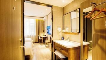 A hotel bathroom with a wooden vanity, a mirror, and a towel rack.