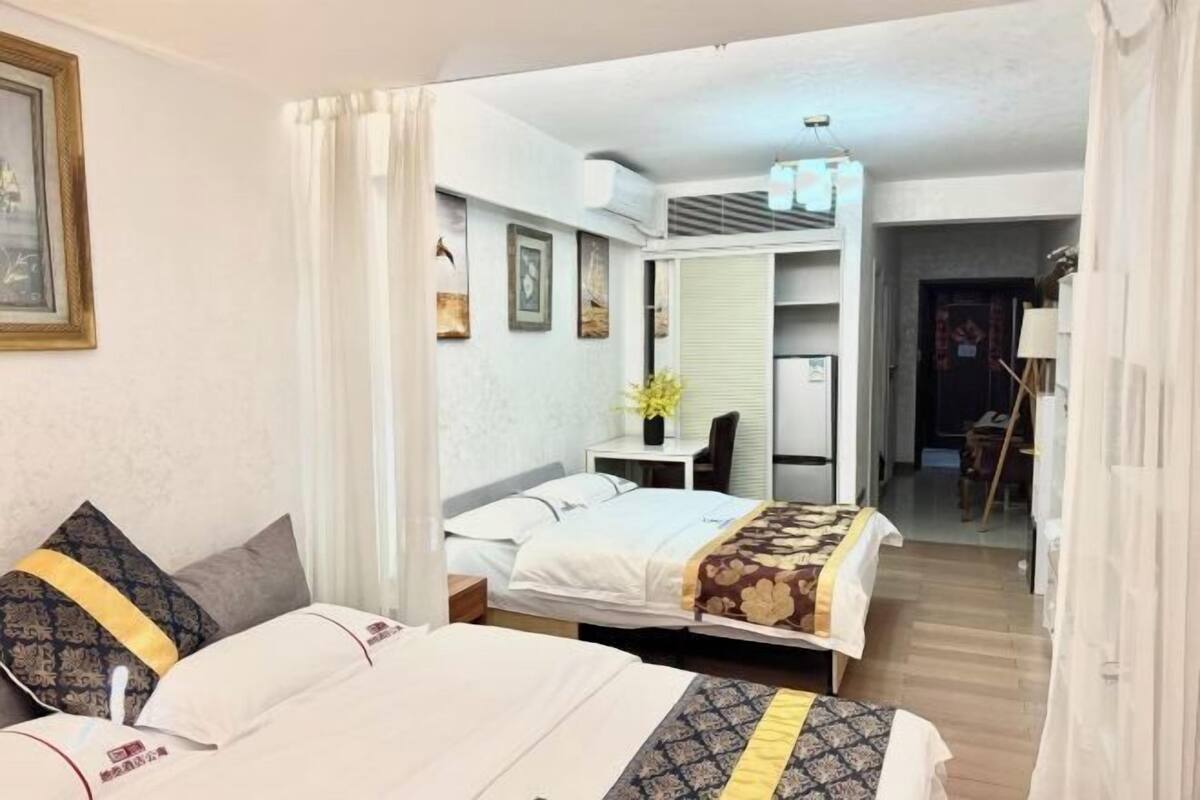 Ein Hotelzimmer mit zwei Betten, einem Schreibtisch, einem Stuhl und einem kleinen Tisch.