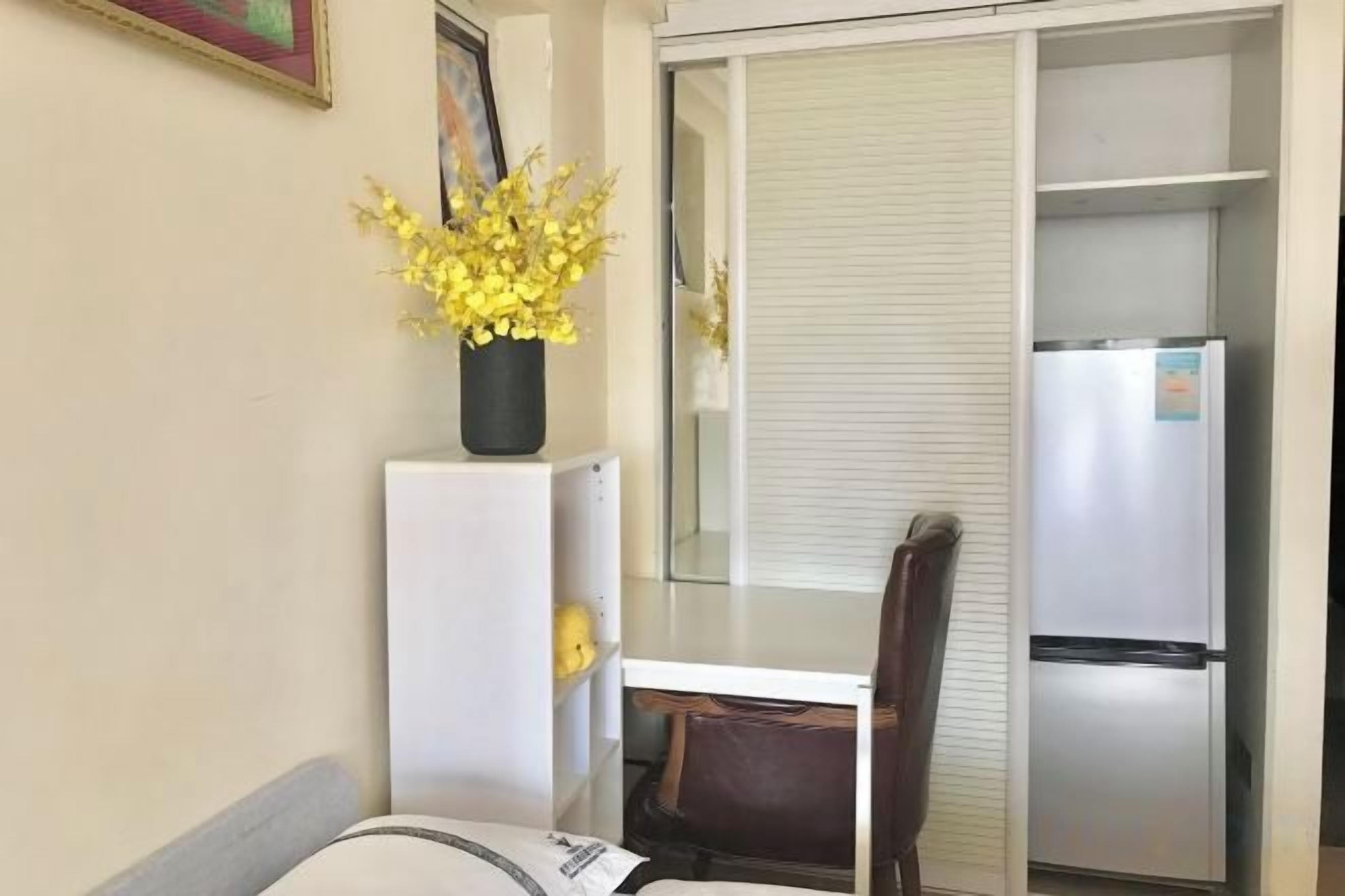 Un espacio habitable compacto con kitchenette, una zona de comedor y una puerta corrediza que da a un balcón.
