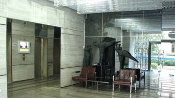 A lobby with a modern design, featuring a large sculpture, seating area, and a glass wall.