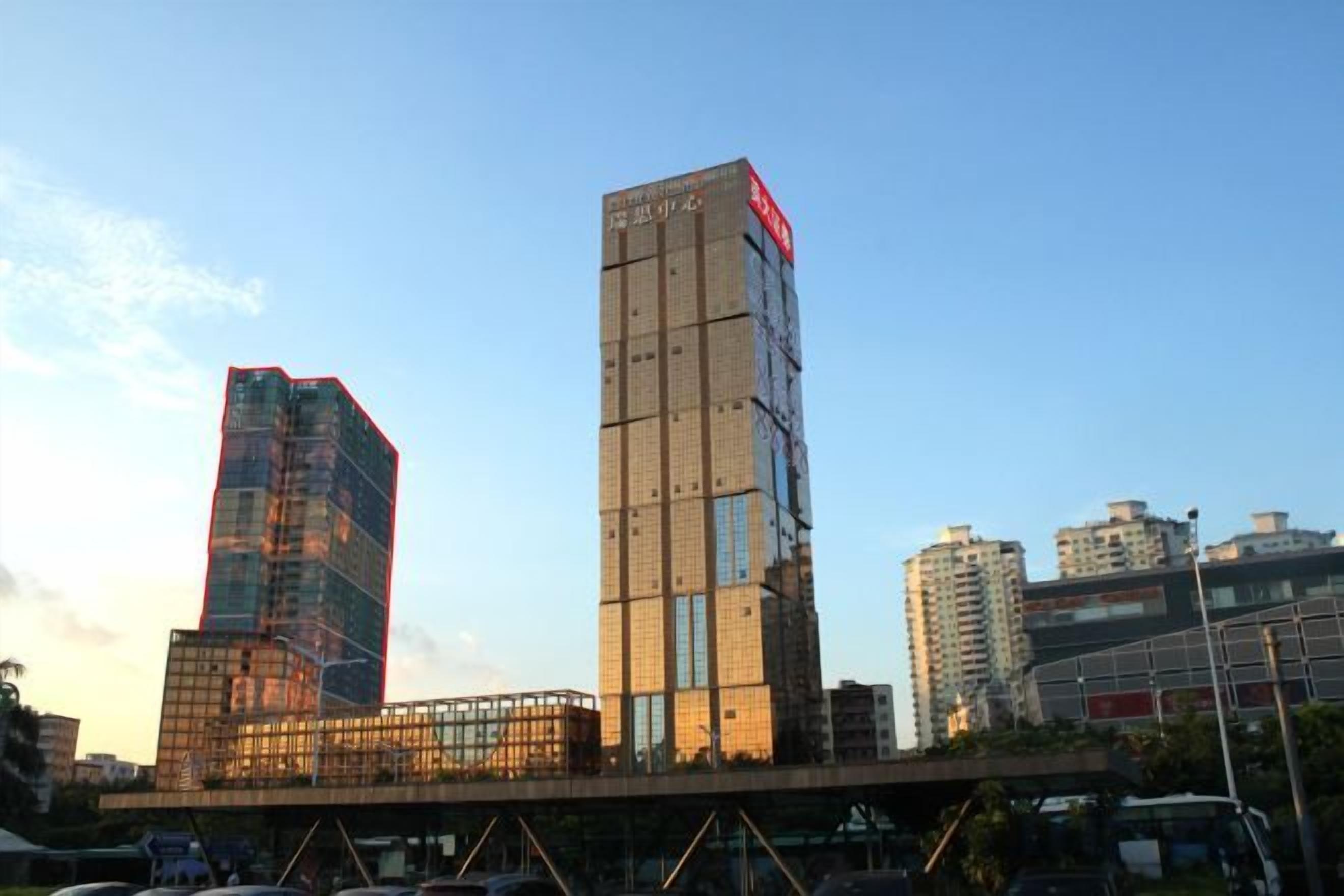 A high-rise building with a modern architectural design, featuring a prominent vertical structure and a series of windows.