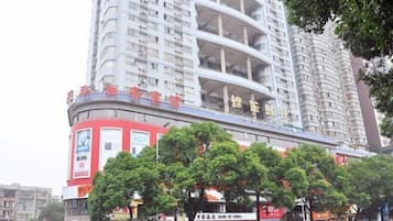 Un hotel de varios pisos con fachada curva, balcones y una decoración en rojo y blanco.