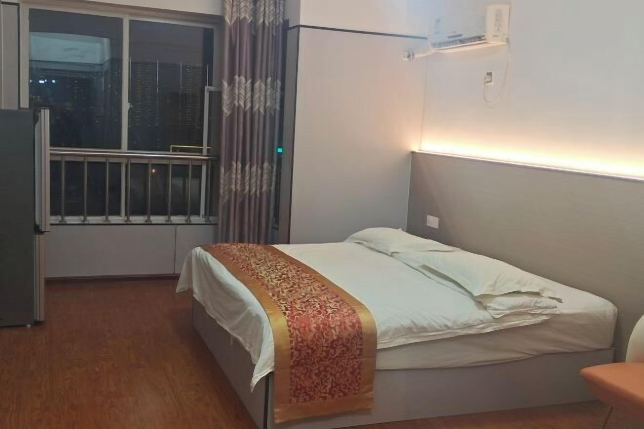 A small, single-bed room with a window, a radiator, and a curtain.