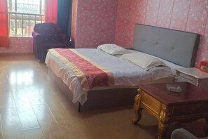 A room with a bed, a chair, a desk, and a window with curtains. - Changsha Jiajia Apartment (Changsha)