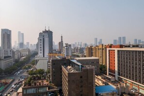 A cityscape with high-rise buildings, a prominent white tower, and a busy street.