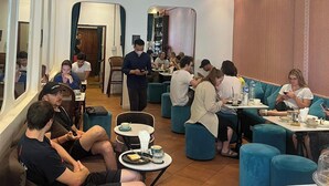 Un área de comedor moderna con mesas redondas y asientos acolchados azules.