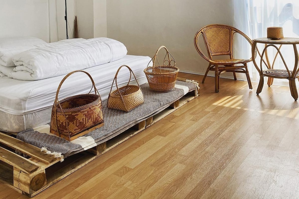 Une chambre à coucher avec un lit, une chaise, une table et une lampe fixée au mur.