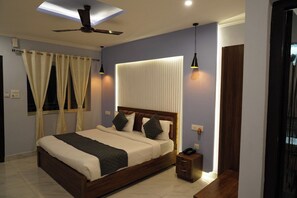 Une chambre à coucher moderne avec un lit, une table de chevet et un ventilateur de plafond.