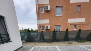 Um espaço de estacionamento no terraço, com telhas cinzentas encaixadas e linhas brancas delimitando as vagas.
