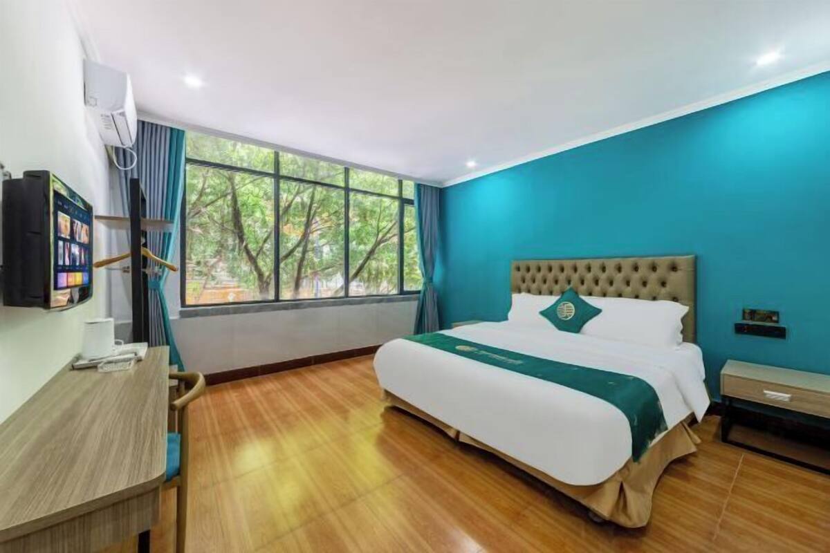 Une chambre d’hôtel avec un grand lit, un bureau et une télévision.