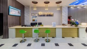 A hotel reception area with a marble counter, three green bar stools, a digital screen, and a ceiling mural. - Yumei Yipin Hotel (Guangzhou Panyu Shiqiao Branch) (Guangzhou)