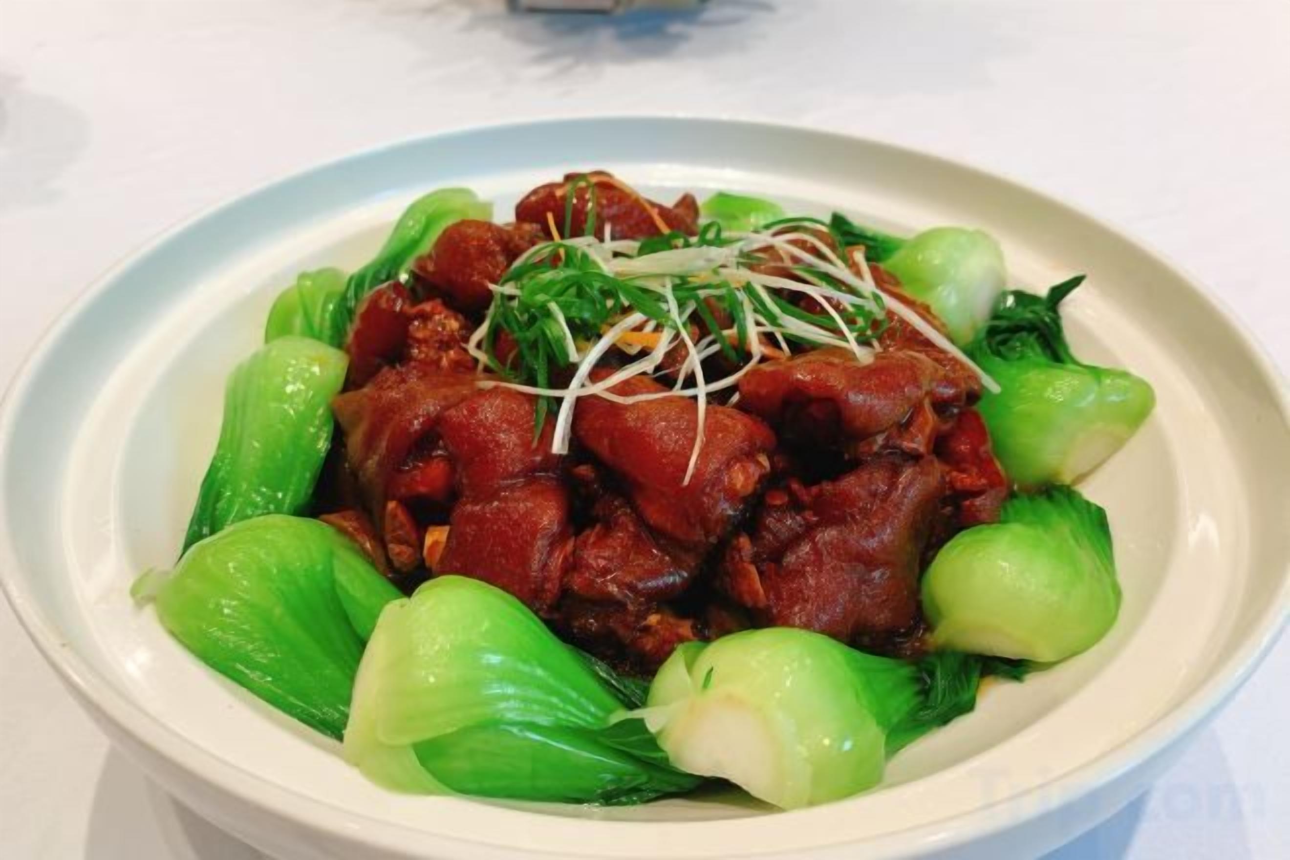 Una ciotola di cibo con carne e verdure verdi.