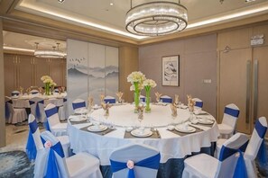 A banquet hall with round tables, chairs, and floral centerpieces. - GanZhouXiangjiangwan International Hotel (South Gate Ancient City Wall) (Ganzhou)