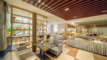 Un hall de hotel con asientos, un mostrador de recepción y una exhibición de objetos.