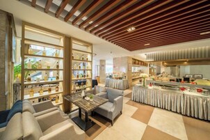 Un hall de hotel con asientos, un mostrador de recepción y una exhibición de objetos.