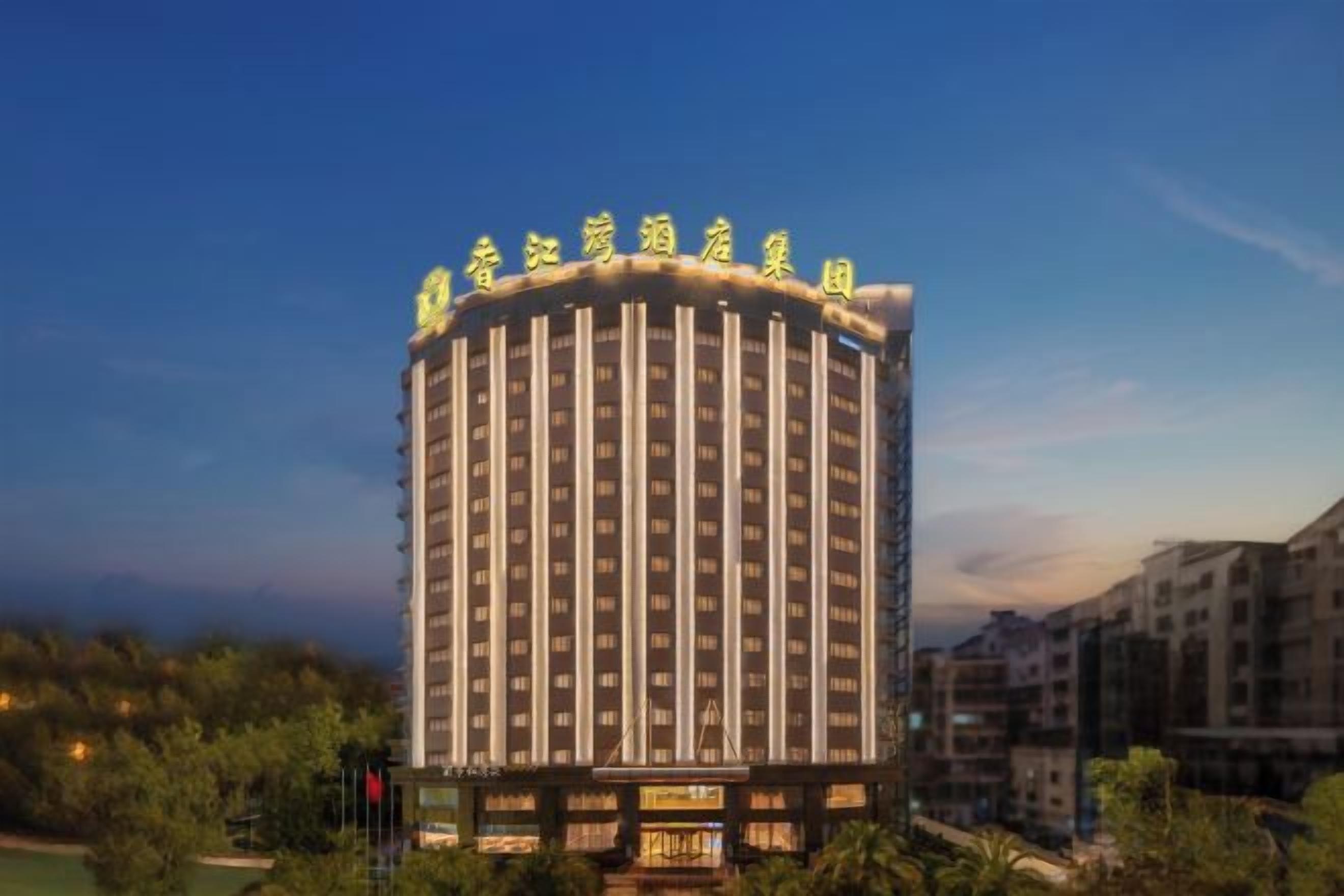 A multi-story hotel with a circular design, featuring a prominent entrance and a series of windows.